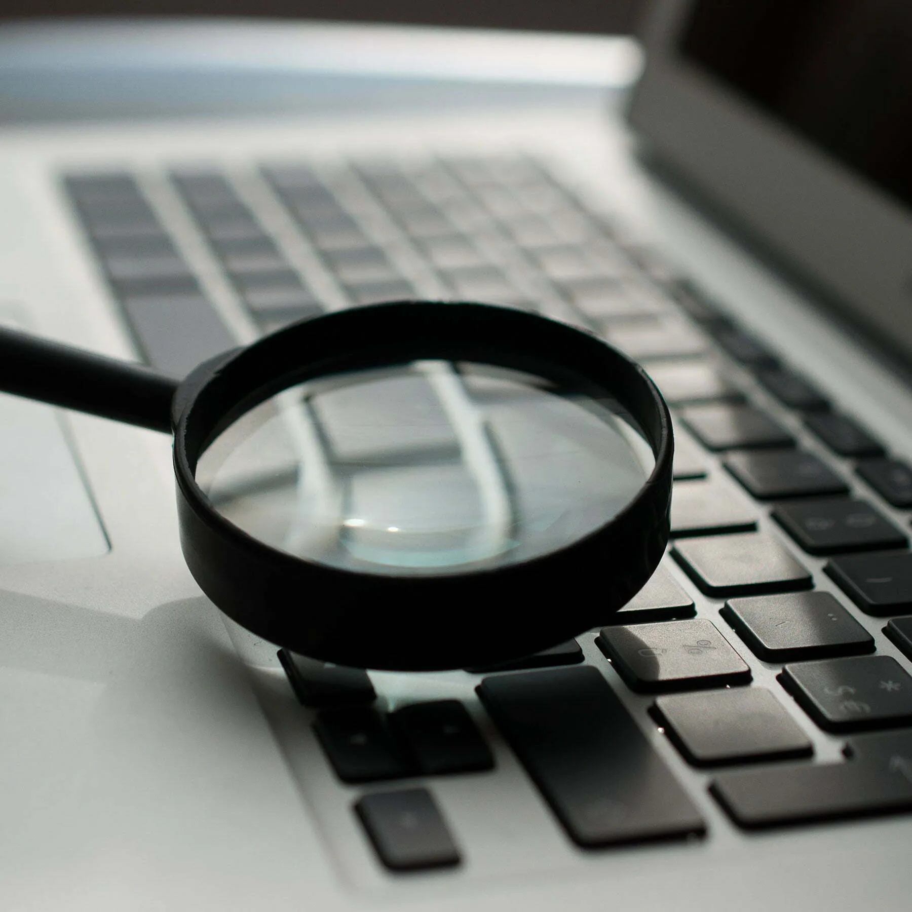 Magnifying glass on laptop keyboard