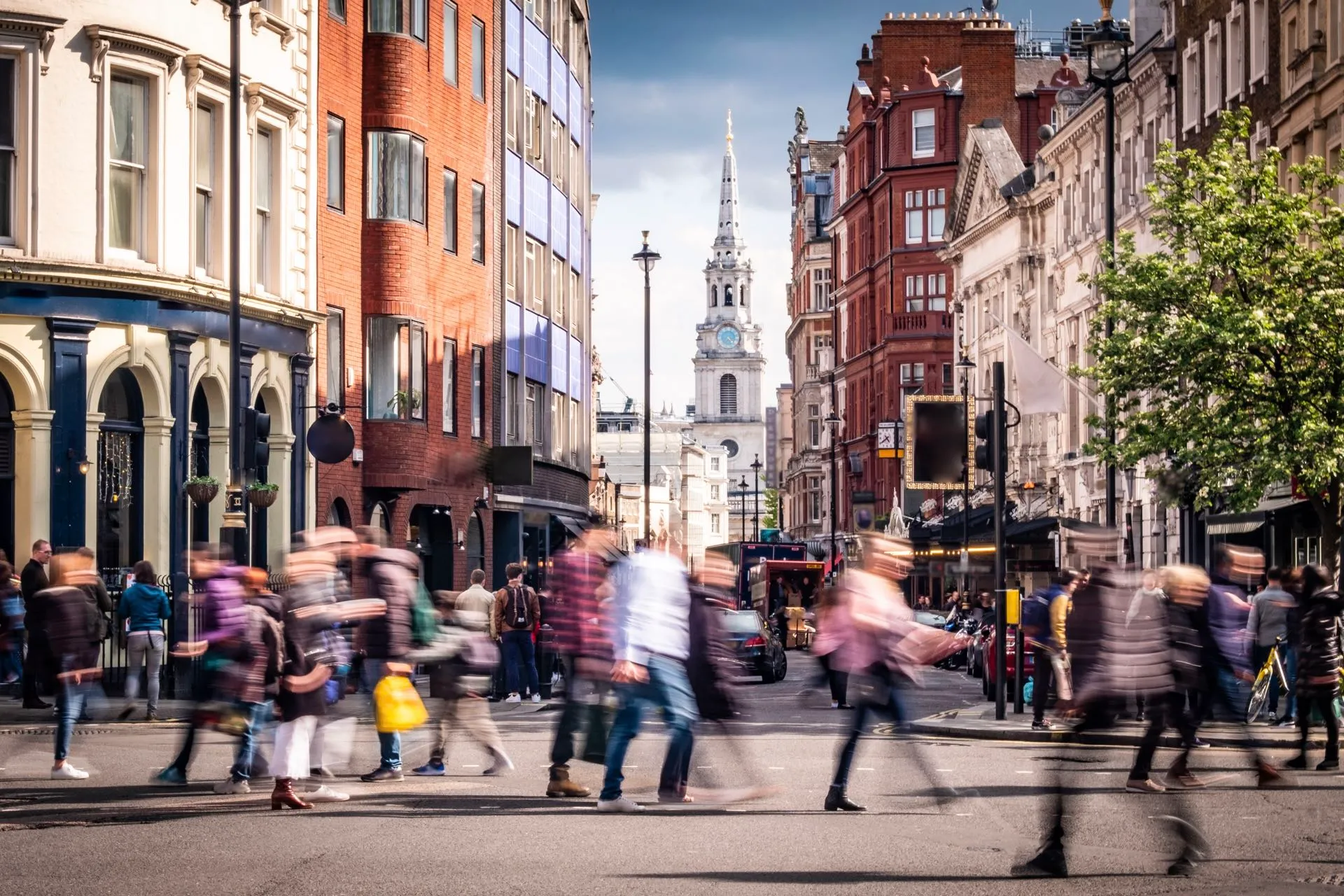 Busy London street with pedestrians and historic architecture.