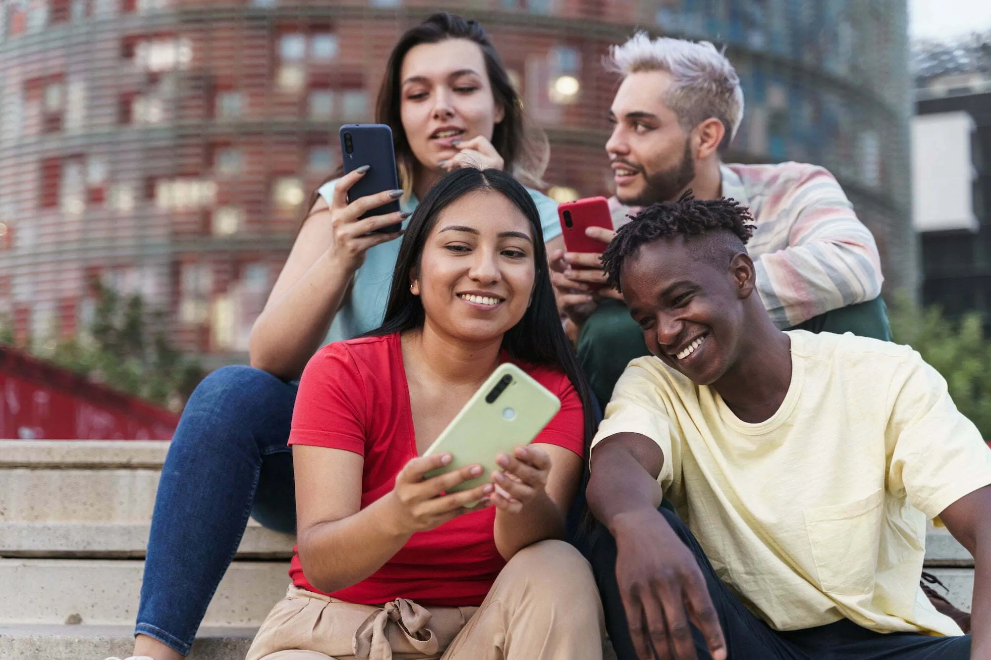 Group of friends using smartphones outdoors